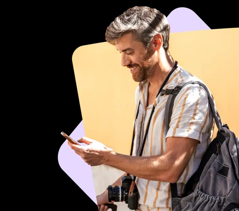 A young man with grey hair wearing a shirt and a bag on his shoulder is using the Bounce app on his mobile phone.